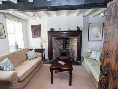 A living room with two sofas and a wood stove fireplace at The Cragg in Hawkshead