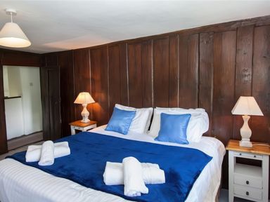 A bedroom with a double bed blue blankets and pillows two bedside tables with lamps at The Cragg in Hawkshead