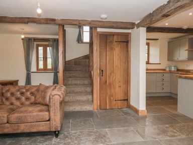 A living room with a couch and stairs at Howgill Head in Kendal