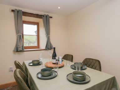 A dining room with a table set for six at Howgill Head in Kendal