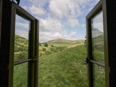 A view from a window showing mountains and grass at Howgill Head in Kendal