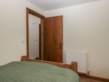 A bedroom with a bed and a door at Howgill Head Kendal