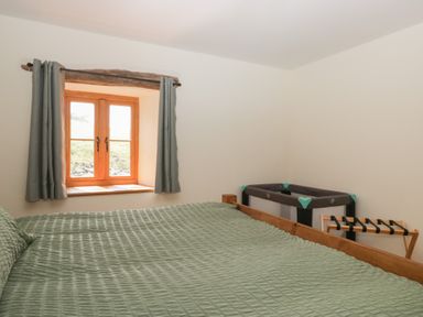 A bedroom with a bed and crib at Howgill Head in Kendal