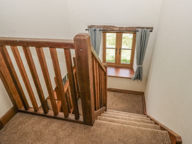 A staircase with a window and curtains at Howgill Head in Kendal