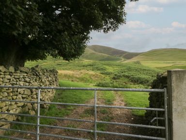 A gate opening to a pathway leading to hills at Howgill Head in Kendal