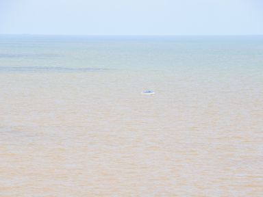 A small boat floating on the sea with a horizon in the background at 98 Waterside Park in Corton