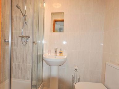 A bathroom with a shower enclosure sink toilet and a mirror at Sunset Lodge in Fortuneswell