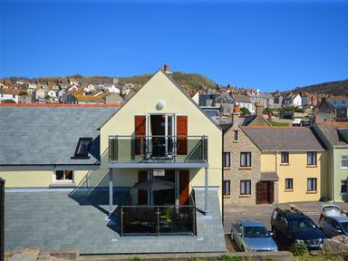 A residential building with two balconies and parked cars in front at Sunset Lodge in Fortuneswell