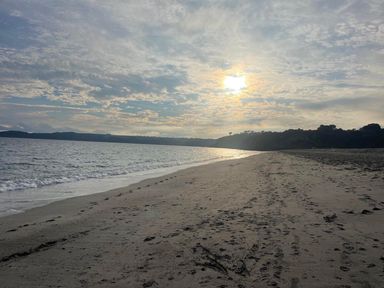 A beach with sand and water under a cloudy sky at Buzzards Lodge near Victoria