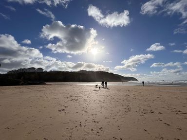 A beach scene with people walking near the water at Buzzards Lodge near Victoria