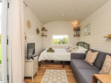 A living room with sofa and television at Buzzards Lodge in Roche