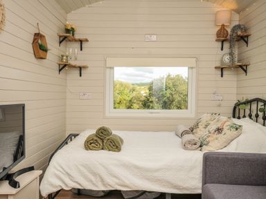 A bedroom with a bed and window at Buzzards Lodge in Roche