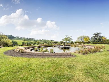 A garden with a pond and fountain at Harcombe House Rooms Accessible Ground Floor Twin in Chudleigh