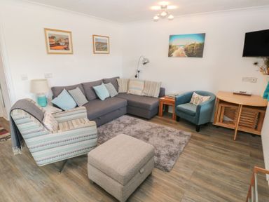 A living room with seating and decor at Puffin Nook in Broad Haven