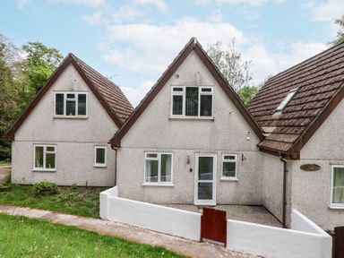 A row of three connected houses with triangular roofs and white walls at 23 Valley Lodge in Gunnislake