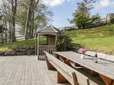 An outdoor area with a wooden table and bench at Cyffdy Cottage - Arenig in Bala