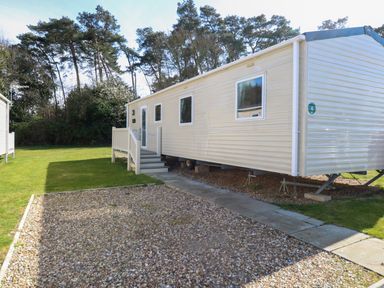 A mobile home with steps leading to the entrance on a grassy plot with trees in the background at 4 Foxburrow Hang in Fritton near Belton Norfolk