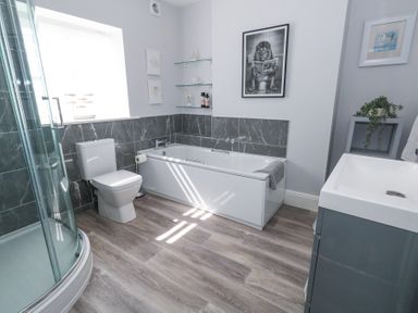 A bathroom with a bathtub toilet shower and sink at Shrimp Cottage in Brewers Quay Harbour