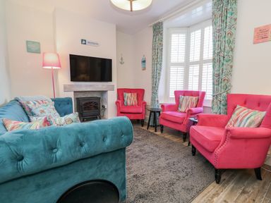 A living room with seating and a television at Shrimp Cottage in Brewers Quay Harbour
