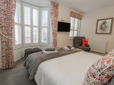 A bedroom with a bed and TV at Shrimp Cottage in Brewers Quay Harbour