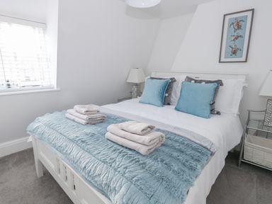 A bedroom with a bed and towels at Shrimp Cottage in Brewers Quay Harbour