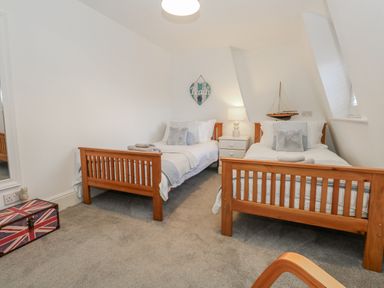 A bedroom with twin beds and a decorative sign at Shrimp Cottage in Brewers Quay Harbour