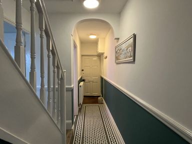 A hallway with a staircase and a door at Shrimp Cottage in Brewers Quay Harbour