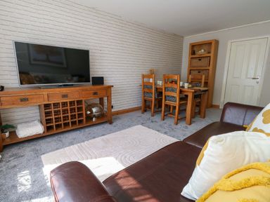 A living room with a television and a dining table at Lily's Pad in Weston, Portland