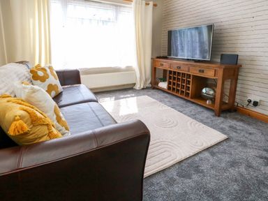 A living room with a sofa and television at Lily's Pad in Weston, Portland