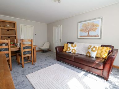 A living room with a dining table and sofa at Lily's Pad in Weston, Portland