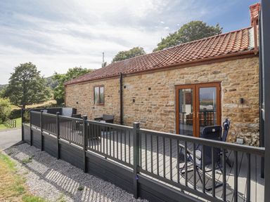 A property with decking and chairs at Birch Cottage in Scarborough