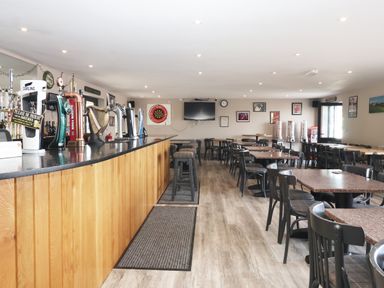A bar with tables and chairs at Birch Cottage in Scarborough