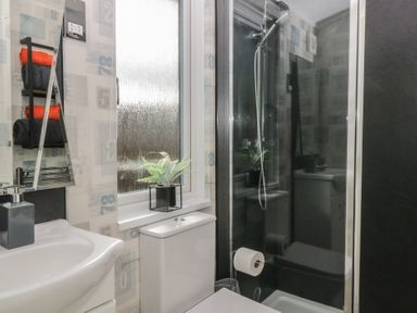 A bathroom with a sink a toilet a shower cubicle and towels on a rack at Gressingham View Lodge in Dock Acres near Carnforth