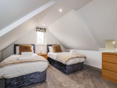 A bedroom with two beds and a window at Tiddlywink near Indian Queens