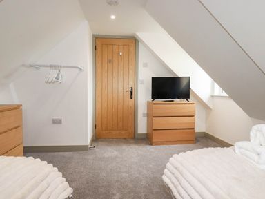 A bedroom with a television and dresser at Tiddlywink near Indian Queens