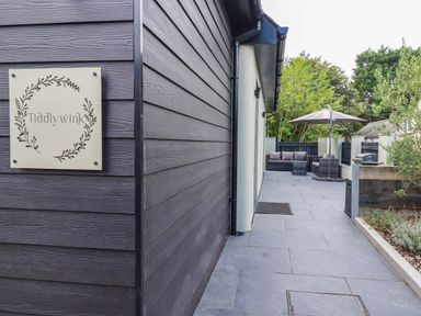 An outdoor area with a seating arrangement and a sign at Tiddlywink near Indian Queens