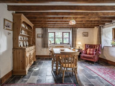 A dining room with wooden furniture at Cove Cottage in Llangrannog