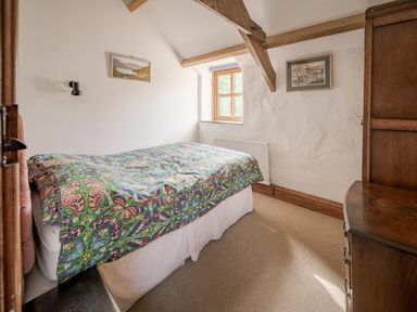 A bedroom with a bed and window at Cove Cottage in Llangrannog