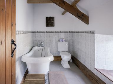 A bathroom with a bathtub and toilet at Cove Cottage Llangrannog