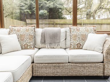 A couch with pillows and a blanket at Y Bwthyn in Llangrannog
