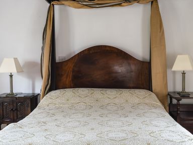 A bedroom with a canopy bed and bedside tables at Y Bwthyn Llangrannog