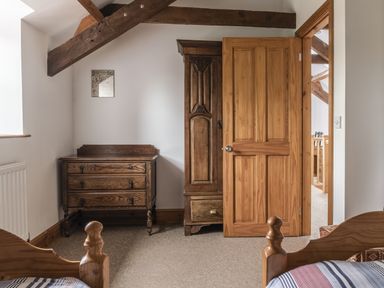 A bedroom with wooden furniture and a door at Y Bwthyn in Llangrannog