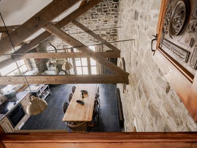 A kitchen with a dining table and chairs at Coach House Llangrannog