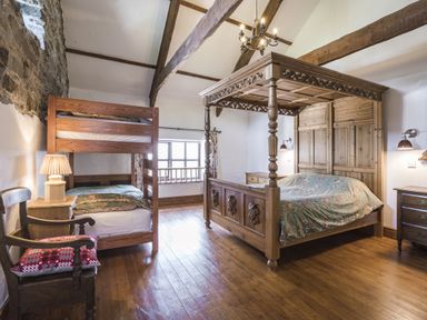 A bedroom with a bunk bed and a canopy bed at Coach House Llangrannog
