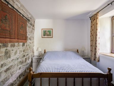 A bedroom with a bed and nightstand at Coach House in Llangrannog