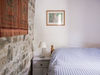 A bedroom with a bed and bedside table at Coach House in Llangrannog