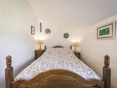 A bedroom with a bed and lamps at Coach House in Llangrannog
