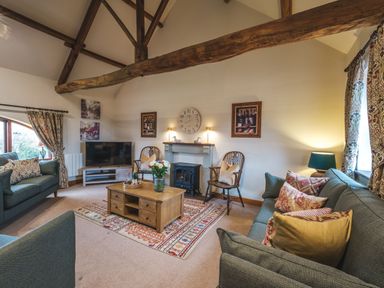 A living room with wooden beams a coffee table and sofas at Beaver Cottage in Little Thirkleby near Thirsk
