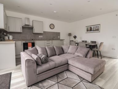 A living room with a sofa and dining area at Castle View in Scarborough