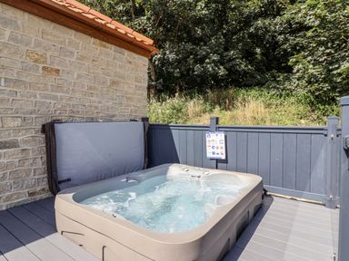 A hot tub on a wooden deck in an outdoor area at Castle View in Scarborough